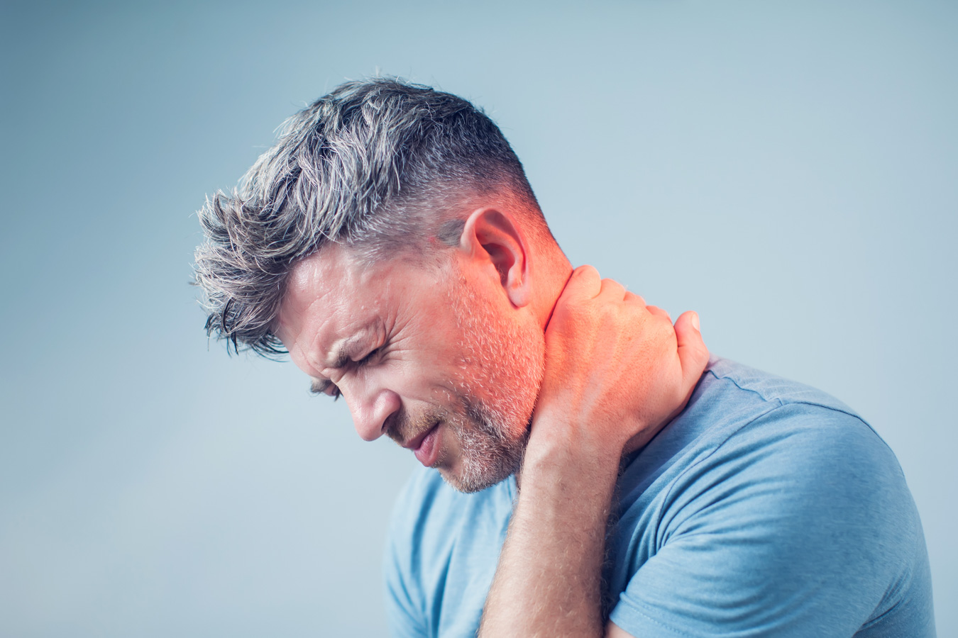 Middle aged man holding neck in pain