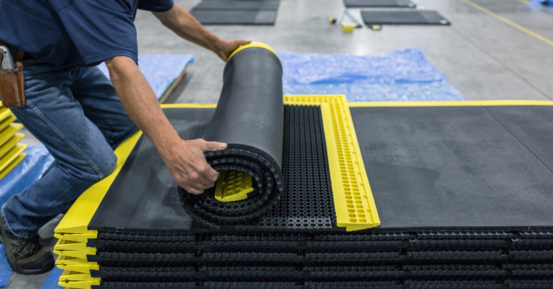 employee rolling up a smartcells custom anti-fatigue solution