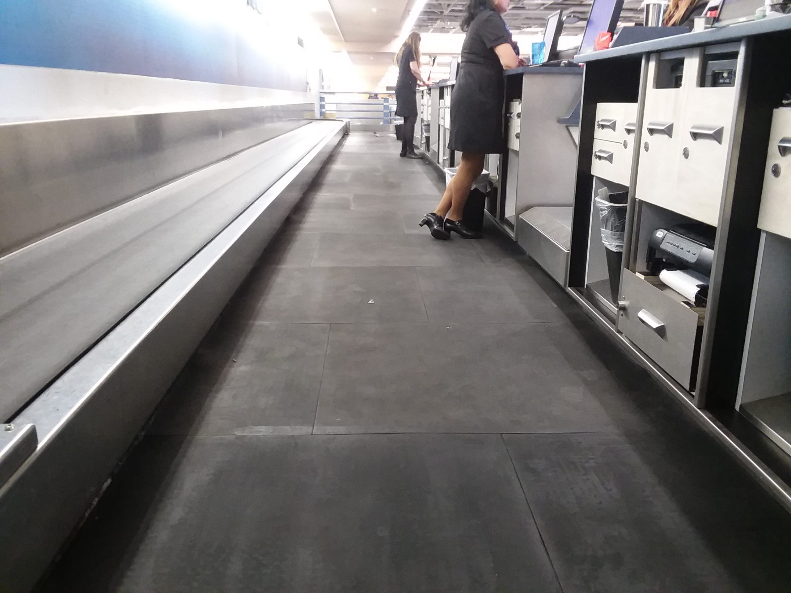 Protect Employees Airline employee working baggage drop off area standing on SmartCells flooring
