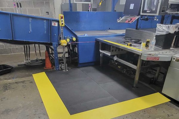 SmartCells Workspace Custom Solutions Older worker sitting in manufacturing environment